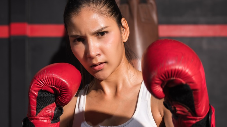 female boxer wearing pony tail and boxing gloves