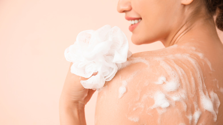 woman using a loofah in the shower