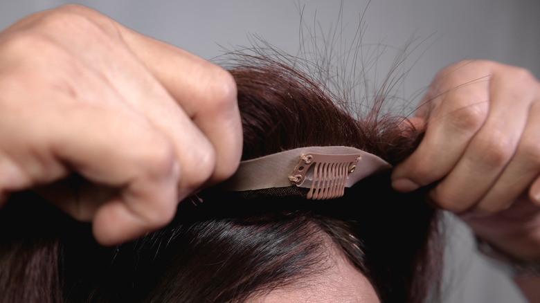 Model putting on a hair topper