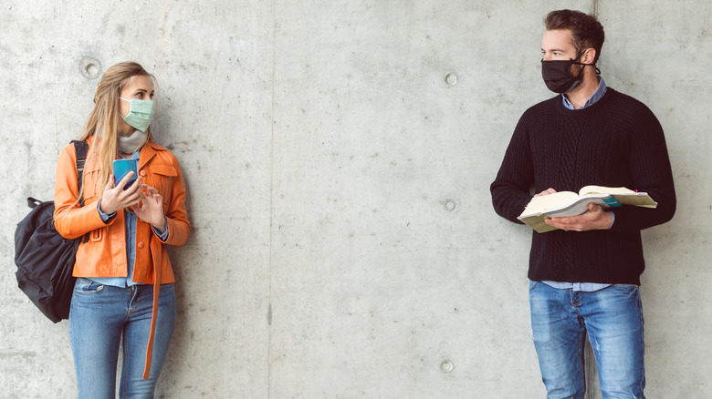 couple standing apart wearing masks