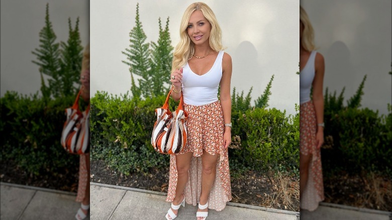 Blond wearing orange high-low skirt