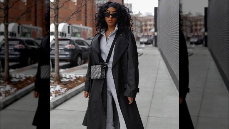 Model wearing tailored trench, grey sweats, and sunglasses