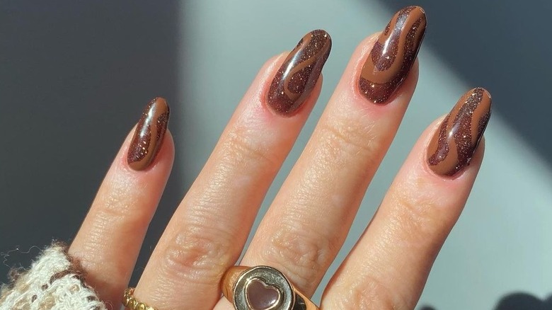 Woman with chocolate glitter nails