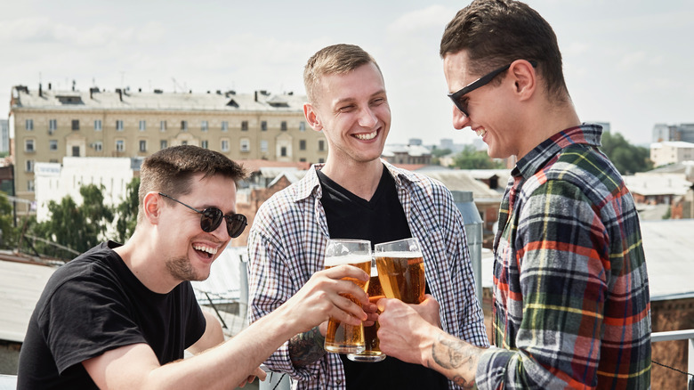 three men drinking beer