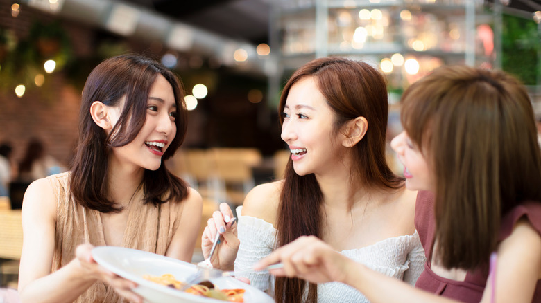 three woman sharing a meal