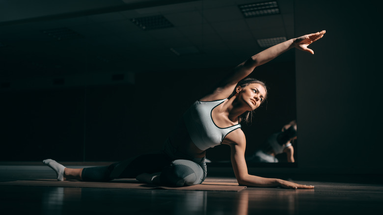 Woman doing yoga in dark studio