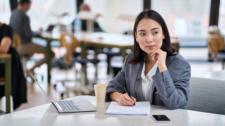 woman thinking and writing