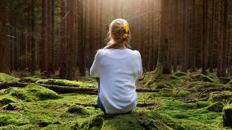 Woman sitting in peaceful forest