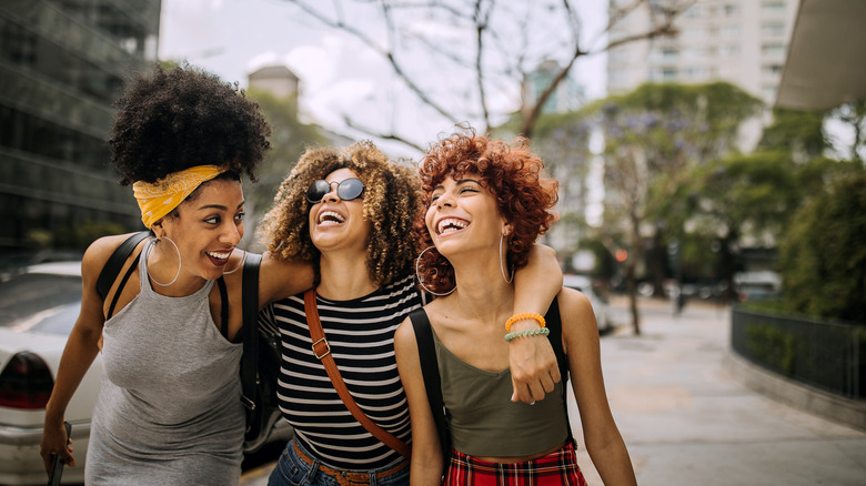 friends smiling walking down street 