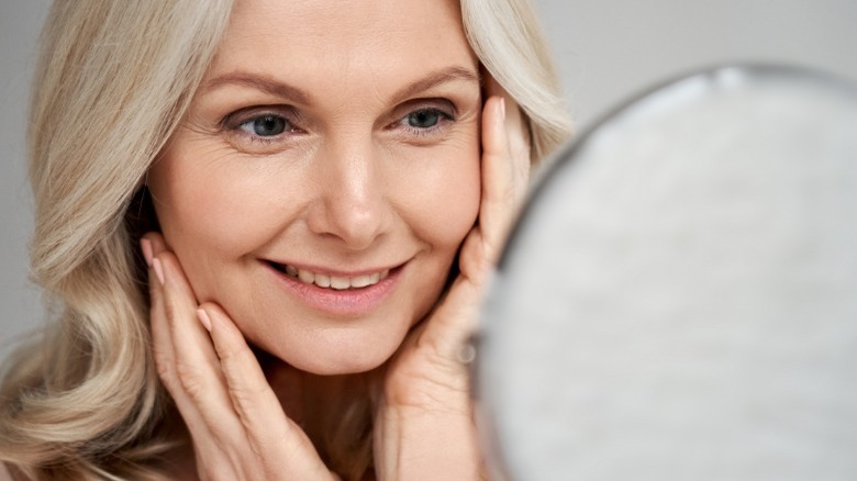 Mature woman looking in mirror