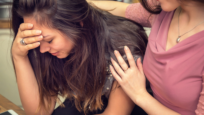 woman crying while her partner comforts her