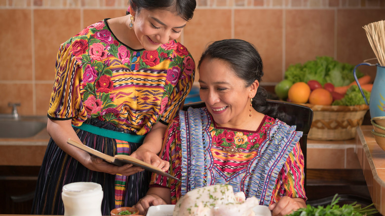 women looking at recipe book