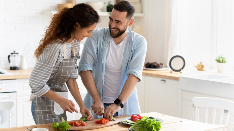 Couple chopping vegetables together