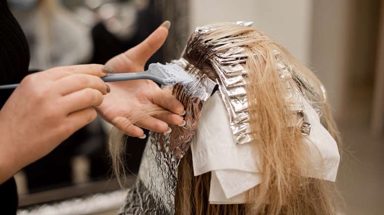 Woman getting hair highlights 