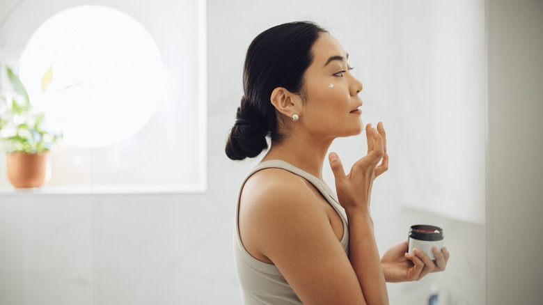 Woman applying moisturizer