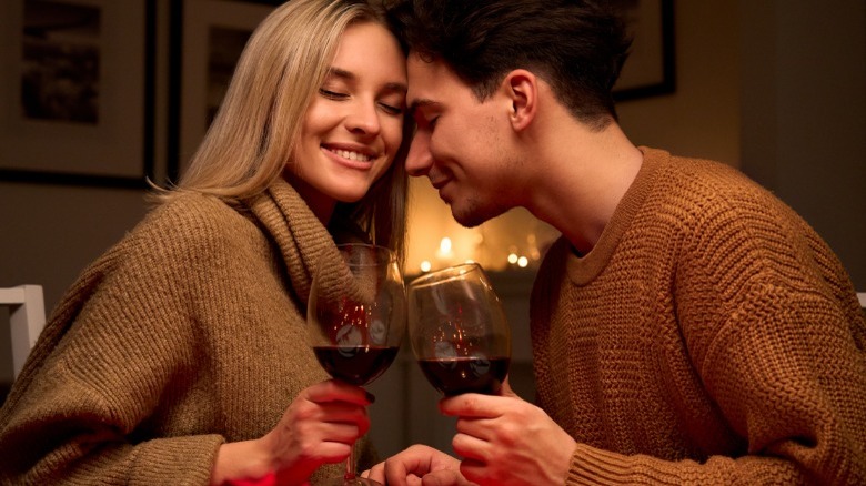 Couple holding wine and smiling