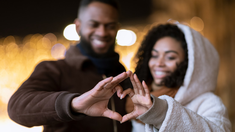 couple making heart with hands