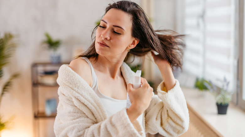 Woman spraying her hair