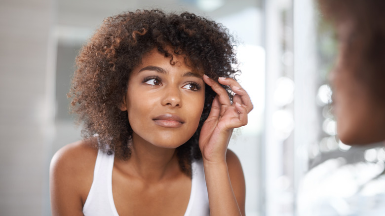 woman looking at her eyebrows