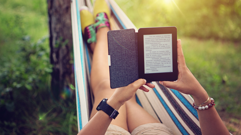 Woman using e-reader in hammock