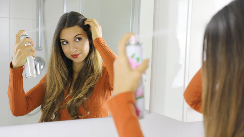 woman styling hair with dry shampoo