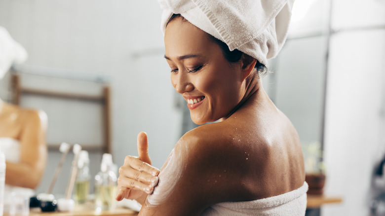 Girl applying cream to her body