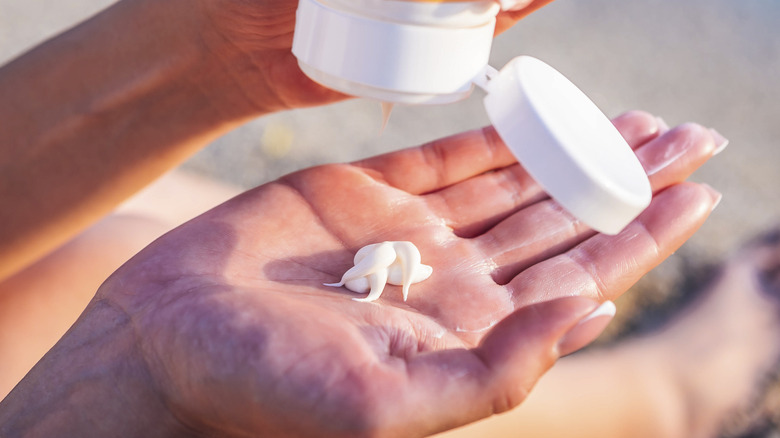 Squeezing sunscreen on hand 