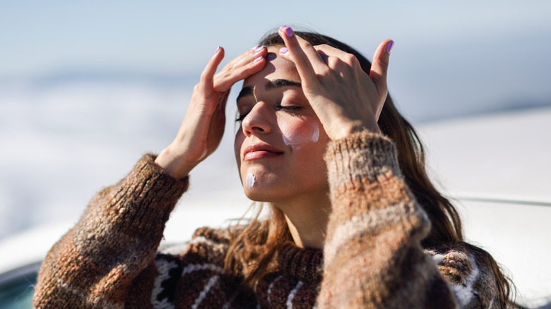 Applying sunscreen on face 