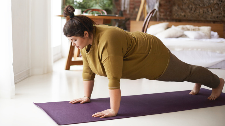 Woman holding high plank pose