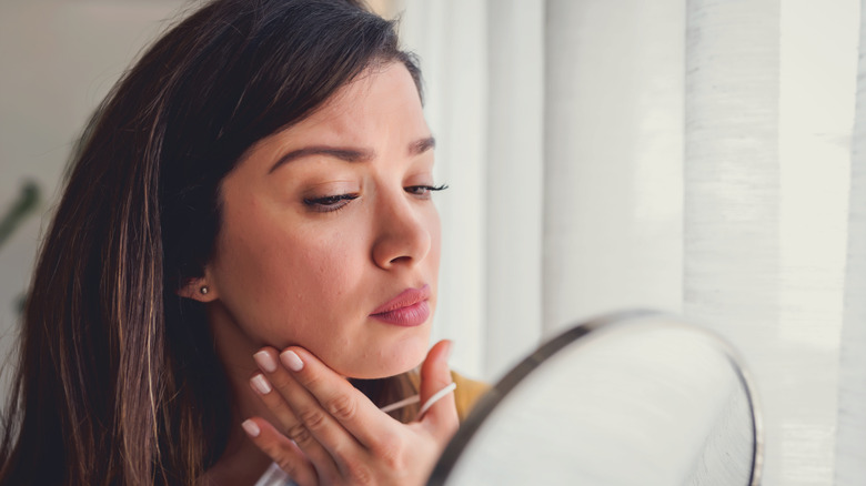 Woman examining skin