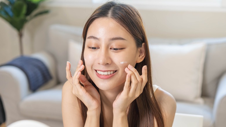 person putting on sunscreen