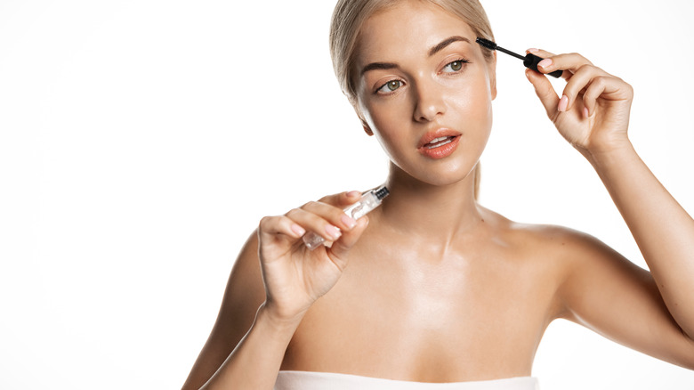 Woman applying eyebrow serum