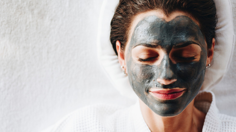 Woman with clay mask on face