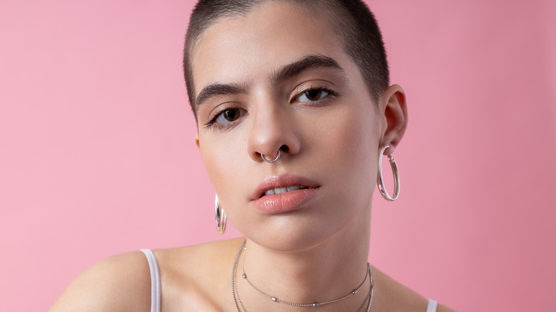 Person with septum piercing and hoop earrings