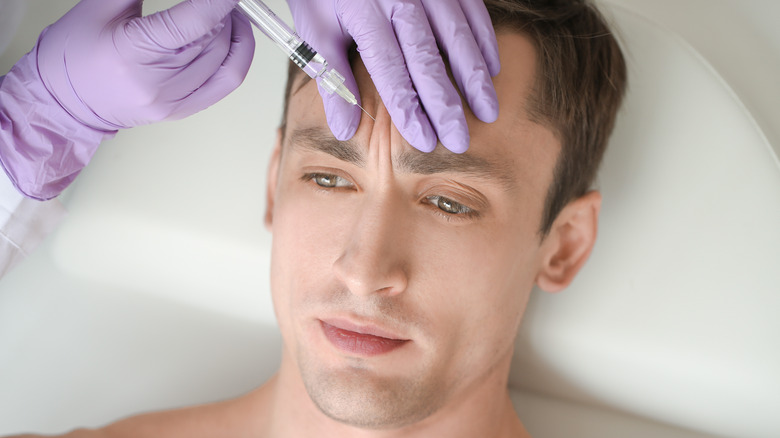 young man receiving botox on frown lines