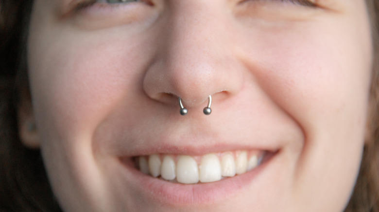 A woman smiling with septum piercing