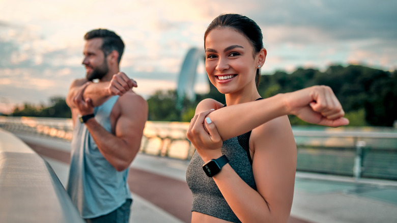 Man and woman holding an arm stretch