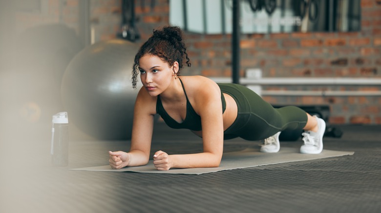 Woman holding plank at gym