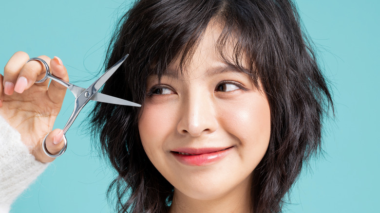 Woman trimming her bangs