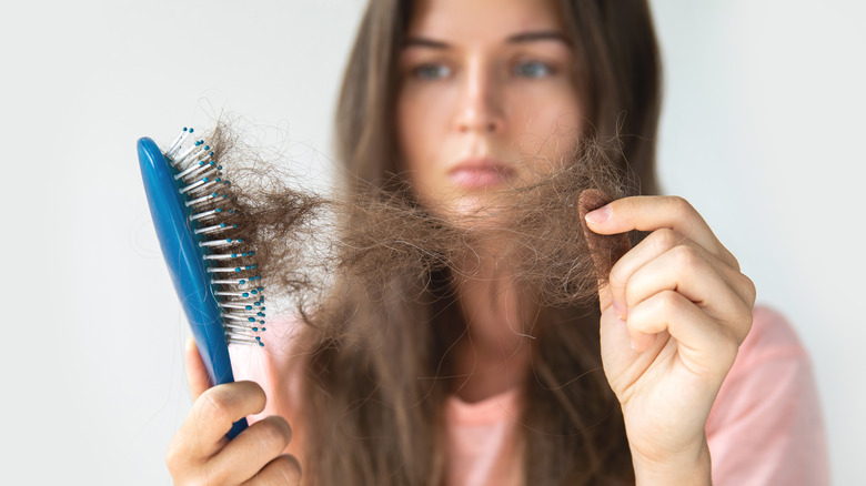 woman removing hair from brush