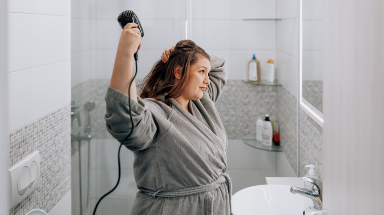 woman blow drying hair