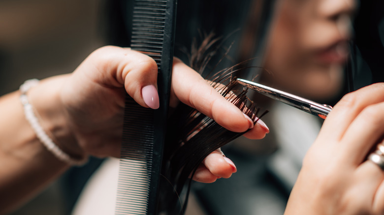 hands with scissors cutting hair