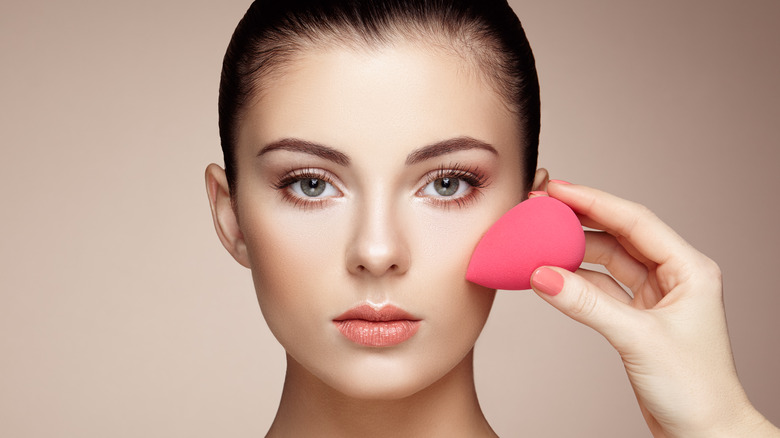 woman using makeup sponge