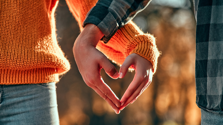 couple holding hands in heart shape