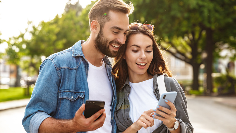 couple looking at phones together 