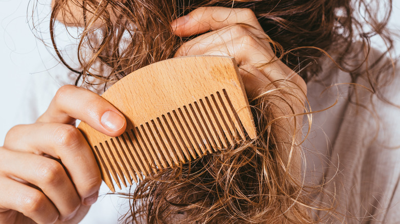 woman trying to comb hair