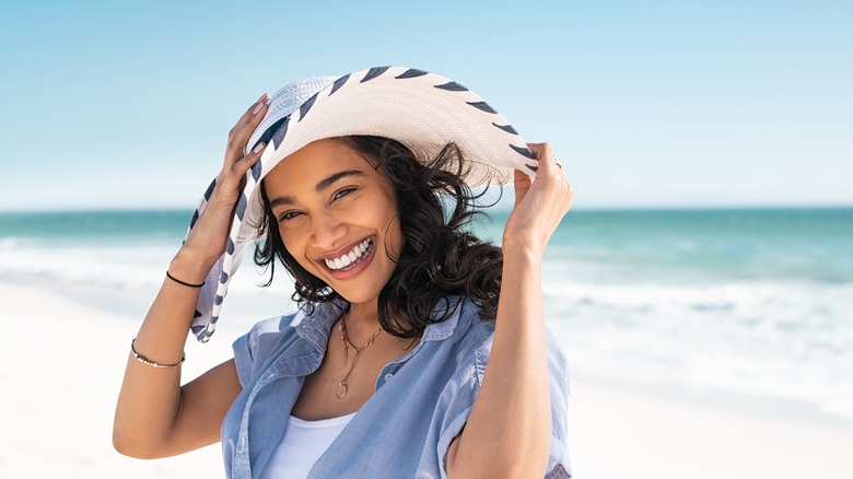 A woman wearing a hat on a beach