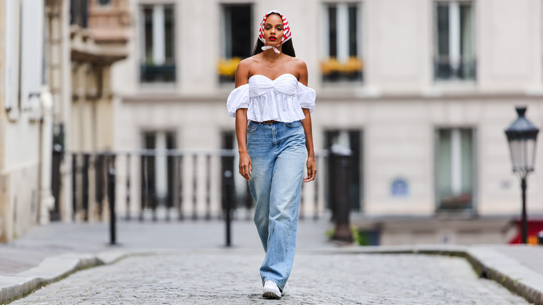 woman wearing an off the shoulder top with jeans