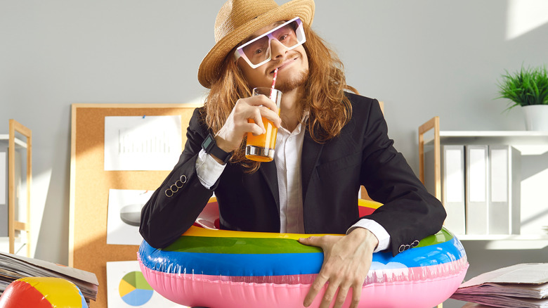 man sipping drink in floatie