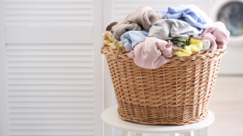 wicker basket with clothes piled on top